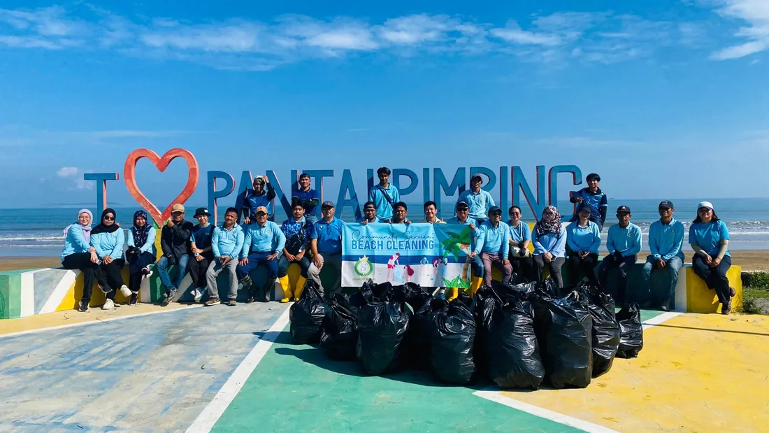 Our team with bags of rubbish after the beach clean-up at Pantai Pimping, 2025